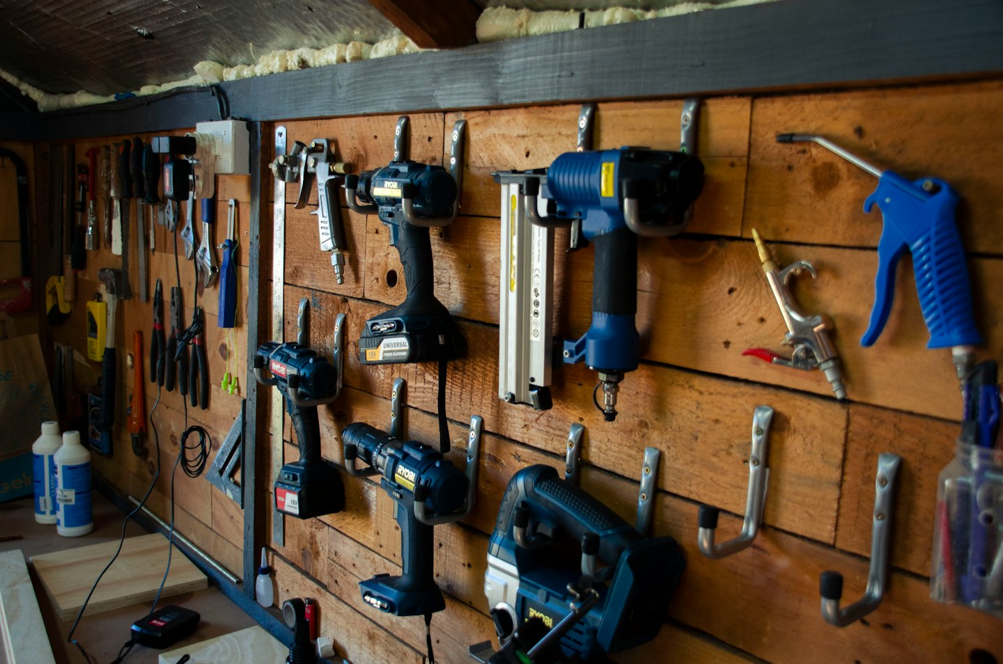 Power and hand tools neatly hung on a workshop wall.