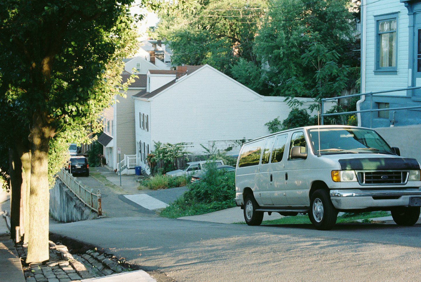 Light grey passenger van parked on a suburban residential street.